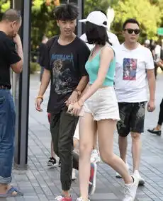 街拍笑容甜美的美女,一件一字肩上衣配牛仔短裤,时尚女性风采