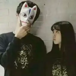 一男一女都穿着黑色衣服,站在哪里的情侣头像,男的手里有个面具把脸挡住了,