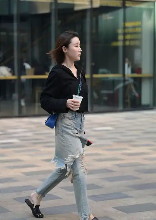 美女黑色短款小卫衣,搭配水洗蓝的破洞牛仔裤,很新潮